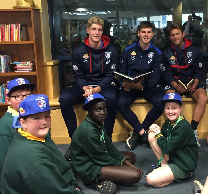 READY: Western Bulldogs Tim English, Billy Gowers and Caleb Daniel read to pupils at Ballarat Library on Tuesday. 