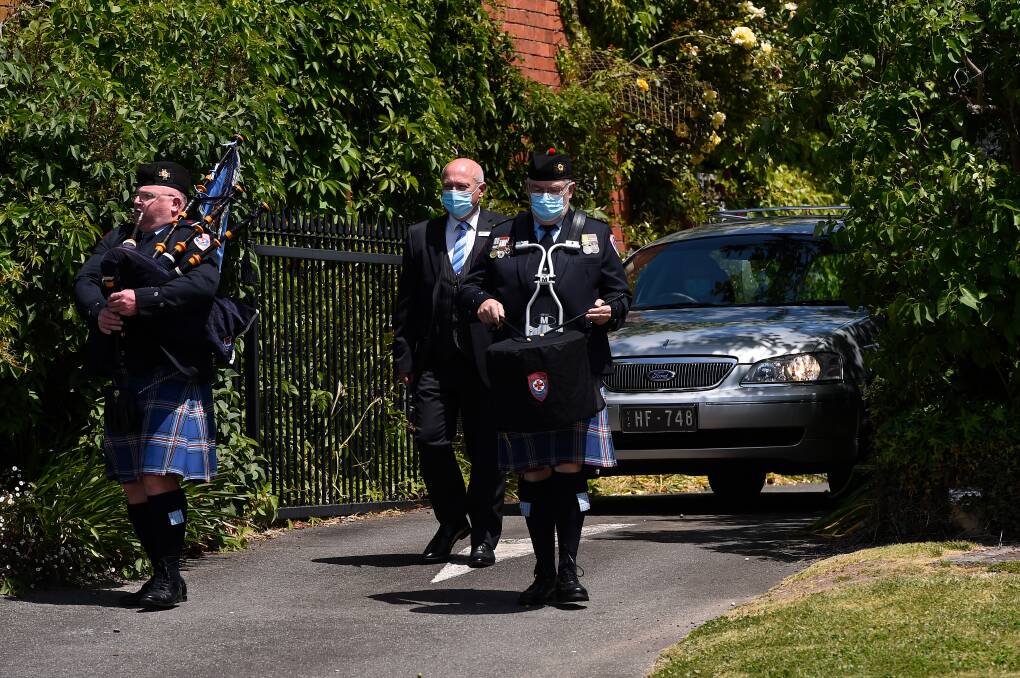 FAREWELL: A piper and drummer escort the hearse to the awaiting ambulance escort for George Prolongeau's funeral on Friday morning. Picture: Adam Trafford