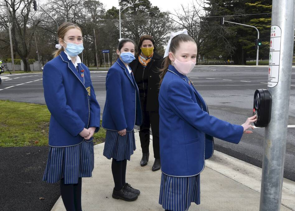 LIGHTING UP: Wendouree MP Juliana Addison tests out the new pedestrian crossings and traffic lights with Loreto year seven students Freyja O'Halloran, Ailish Ryan and Johanna Addison on Monday morning. Picture: Lachlan Bence