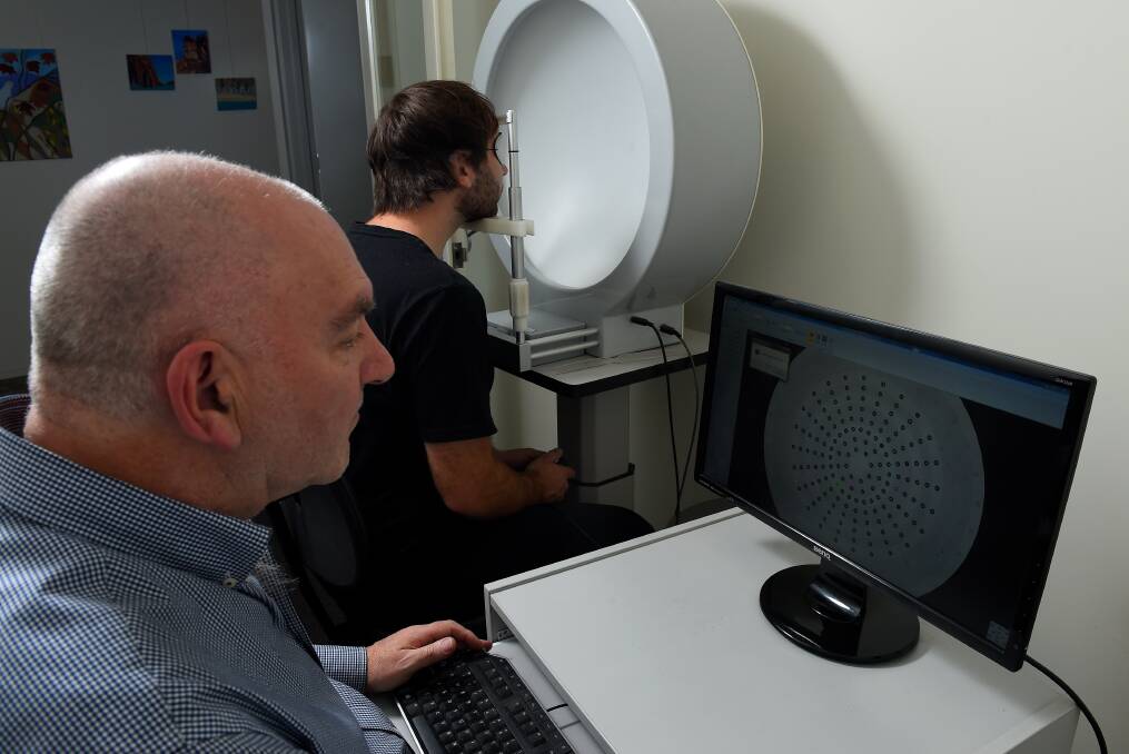 PERSPECTIVE: Ballarat optometrist Peter Fairbanks runs a visual field test on his son, mountain bike rider Marcus Fairbanks, which he says can help gauge concussion effects. Peter Fairbanks is calling on more sports to consider the test to help measure lingering injury. Pictures: Adam Trafford