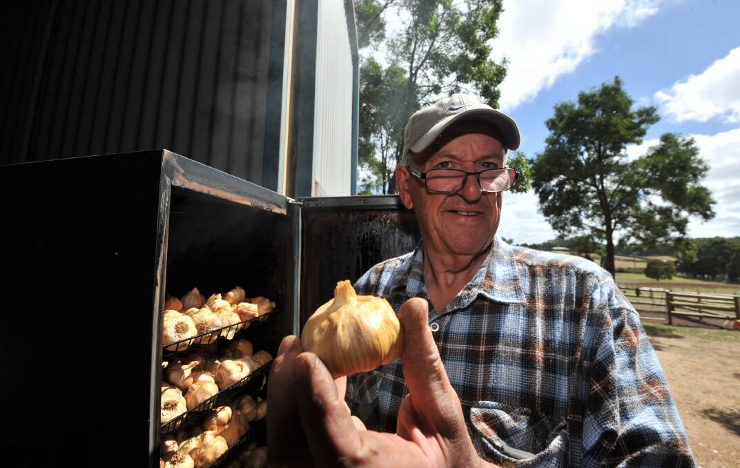 HOMEGROWN: Harmony Garlic's Brian Woodstock unleashes the smell of smoking product, which he sells in a range at farmers markets and, increasingly, in retail produce stores. Picture: Lachlan Bence