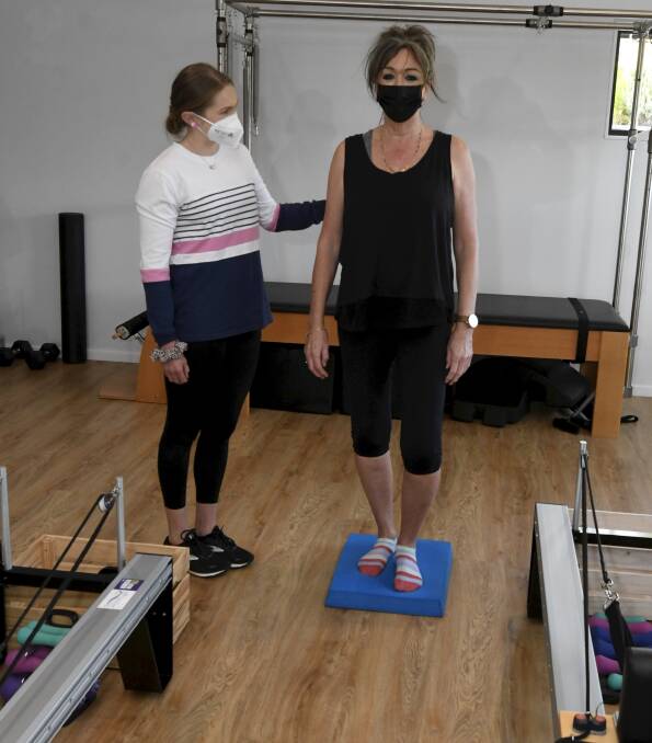 STRONG: Exercise physiologist Abby Byrne guides client Karen Park in stability exercises to ensure she maintains sound balance to prevent falls. Picture: Lachlan Bence