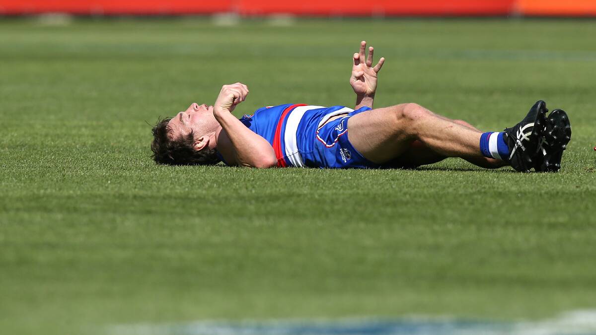 GAME OVER: Western Bulldog Liam Picken is knocked out in a pre-season game in March 2018 and retired this week still feeling effects of concussion. Picture: Wayne Ludbey