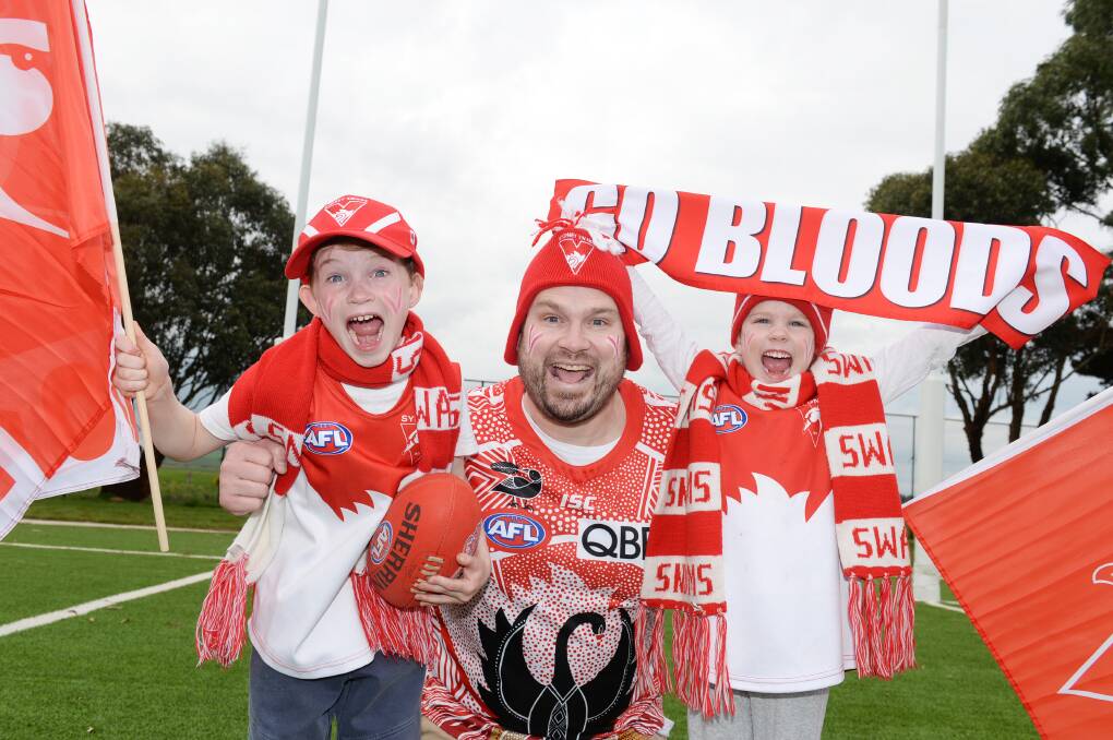 Sydney Swans supporters Mark Bruty (centre) with his children Edwin, age seven, and Mia, age five, are ready to cheer loud. Picture by Kate Healy