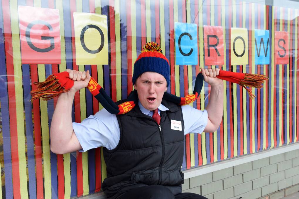 TRUE COLOURS: Beaufort Supa IGA's Liam Christian has been serving customers with a side of "go Crows" as the town turns navy blue, yellow and red. Picture: Kate Healy