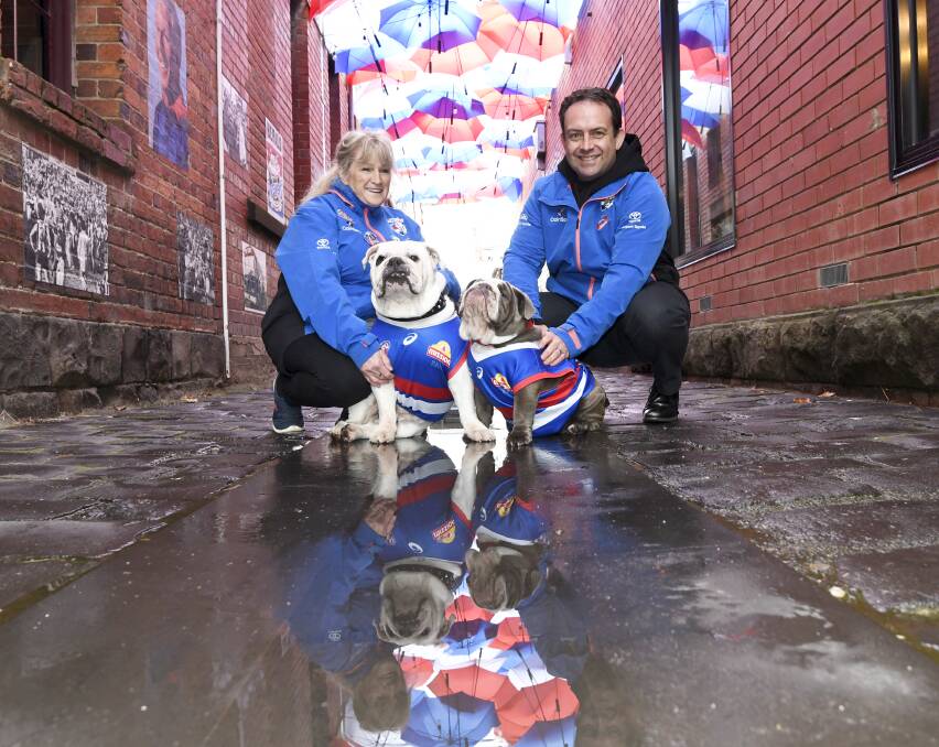 Western Bulldogs mascots Caesar and little mascot-in-training Sunny get down to the Bulldogs' themed Hop Lane with Tanya Templeton and Campbell Waring ahead of this Saturday's AFL match. Picture by Lachlan Bence