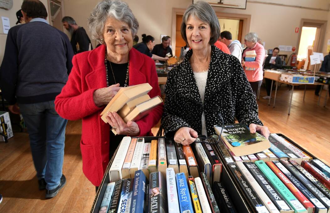 GOOD READ: Bonanza goers Evelyn Wallis and Kerryn Quick check through the cheap, quality books early in the annual event on Saturday. Picture: Lachlan Bence