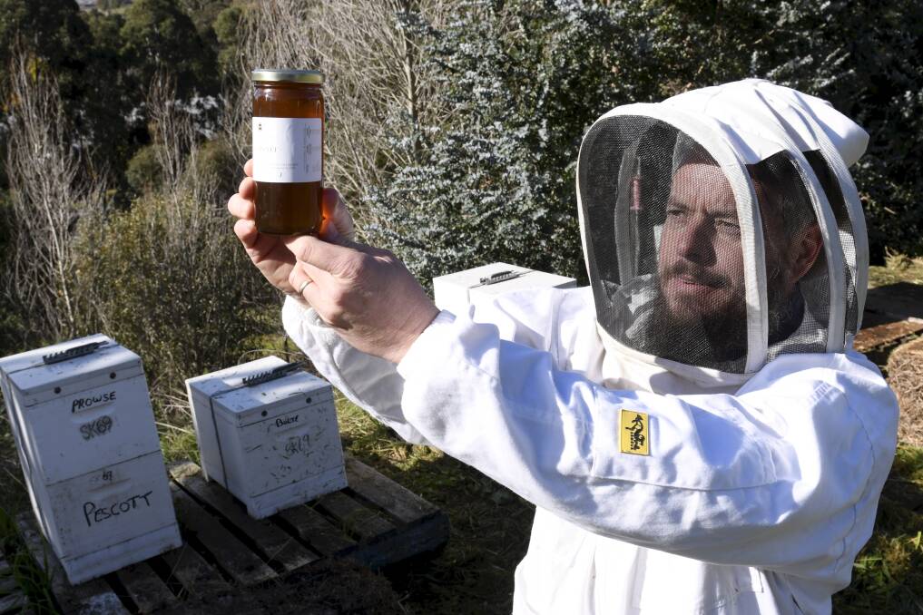 TASTER: Sovereign Hill operations manager and apiarist Jarrod Page produces a jar of raw honey harvested from the museum's hives. Sovereign Hill's raw honey is now available to the public. Picture: Lachlan Bence