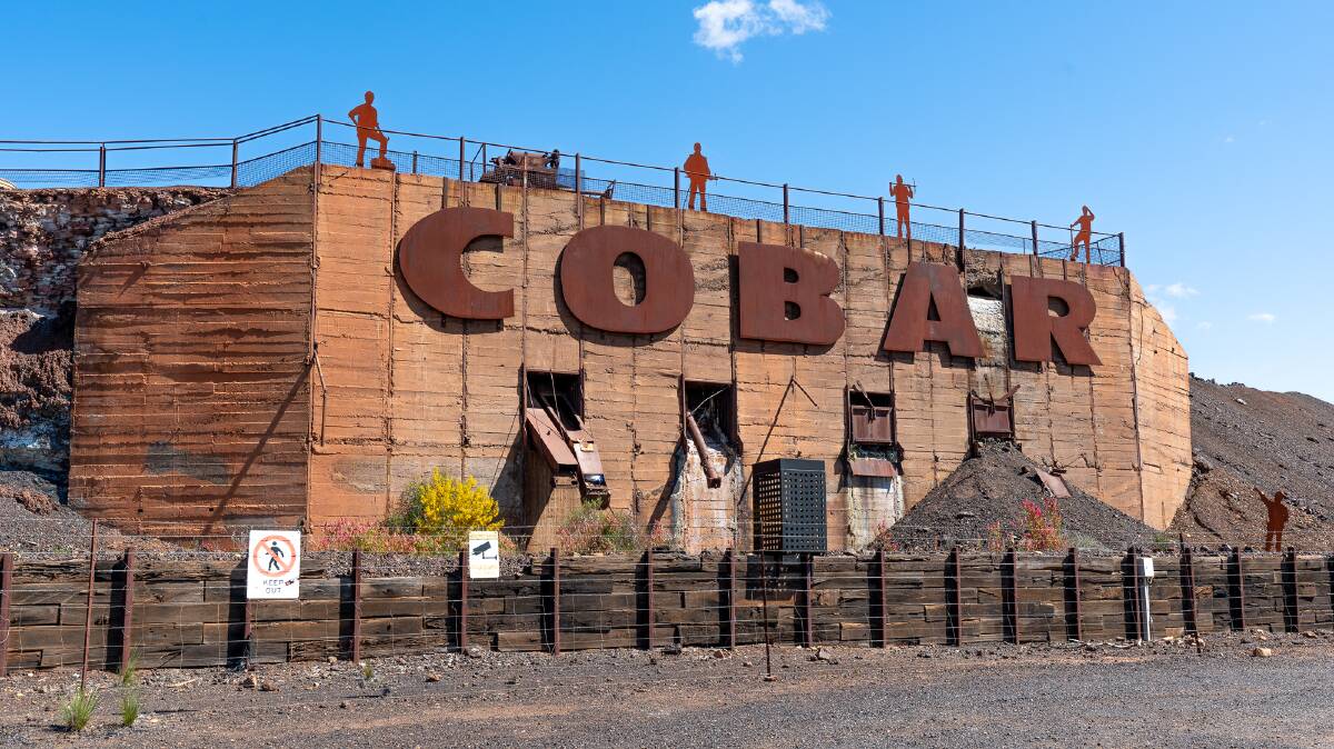The large sign on the side of a slag heap welcomes visitors to Cobar.