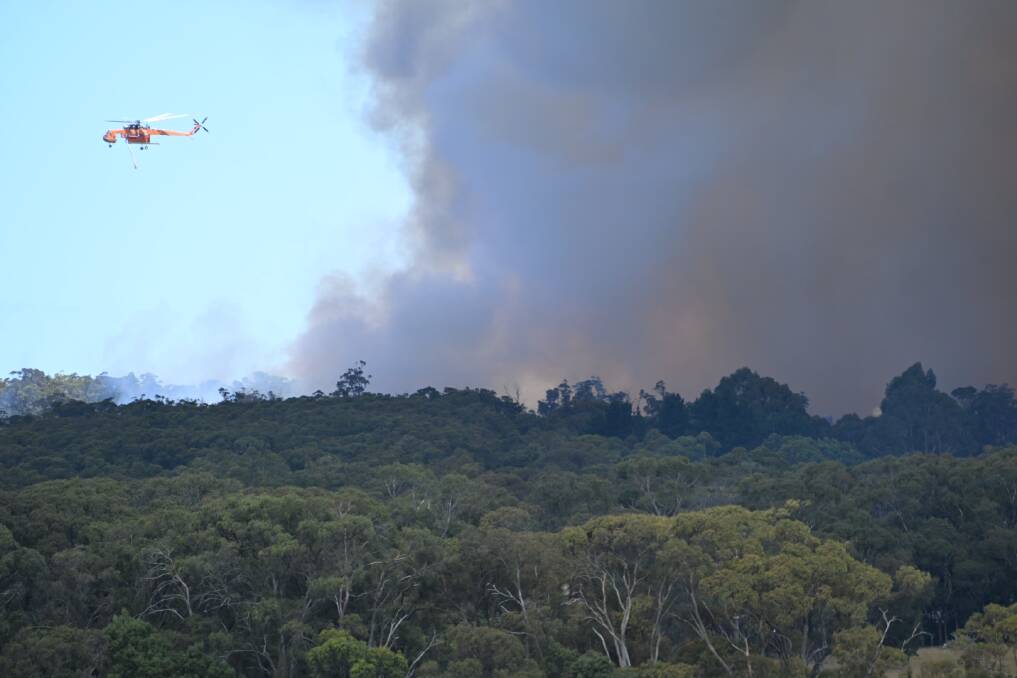 A helicrane circles the Ross Creek fire on Wednesday. Picture by Kate Healy