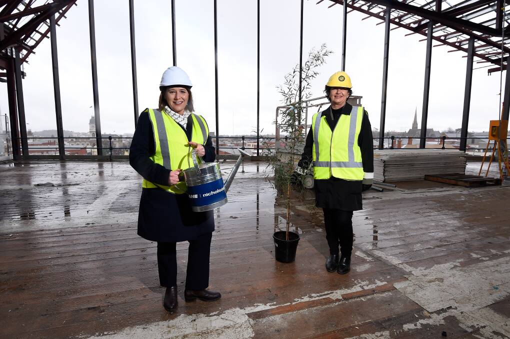 Wendouree MP Juliana Addison and Buninyong MP Michaela Settle with the topping out ceremony tree - the traditional ceremony will "ward off evil spirits", and the tree will be planted nearby. Picture: Adam Trafford