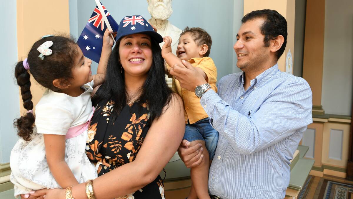 Angela and Thomas Girgis help mum Maryan Bottros with a new hat after she became an Australia citizen, with husband Tony Girgis. Pictures: Lachlan Bence