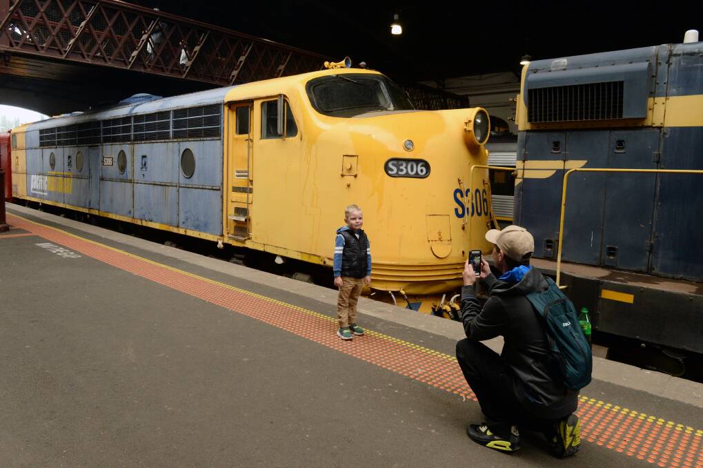 Daniel Gallagher taking photos of Thomas Gallagher, 5, in front of the train at Ballarat train station. Picture: Kate Healy