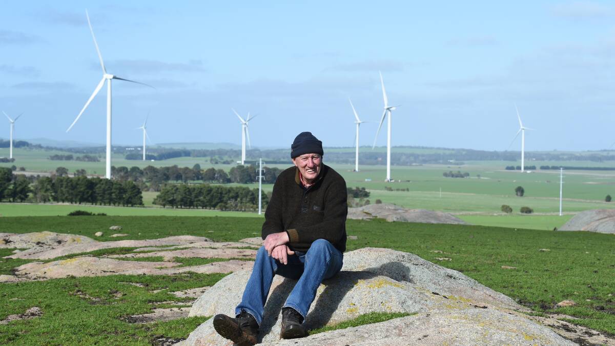 Future: Pittong sheep farmer Alan Pitcher, who has turbines on his property, said there's more positives for the entire community than negatives. Behind him, the Stockyard Hill project is under way. Pictures: Kate Healy