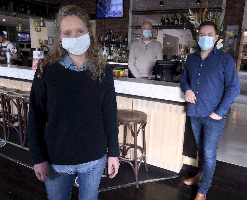 Mask on: Commerce Ballarat board member Alicia Linley, the Western Hotel's Dan Cronin, and the Golden City Hotel's Tim Kearney are urging people from lockdown zones to stay out, and help keep Ballarat safe. Picture: Lachlan Bence