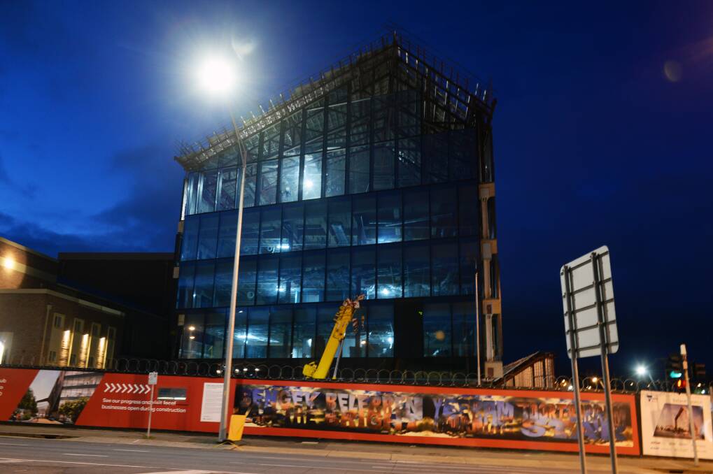 Lit up: The GovHub construction site at dusk. Picture: Kate Healy