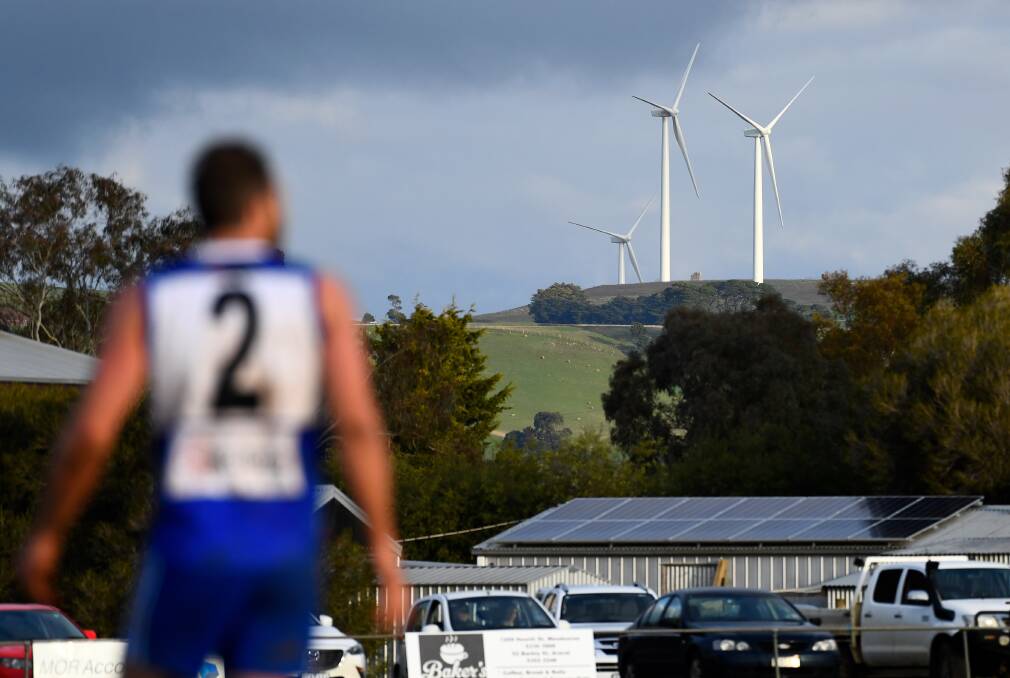 A Waubra footballer during a match last month, with wind turbines on the hill nearby. Picture: Adam Trafford