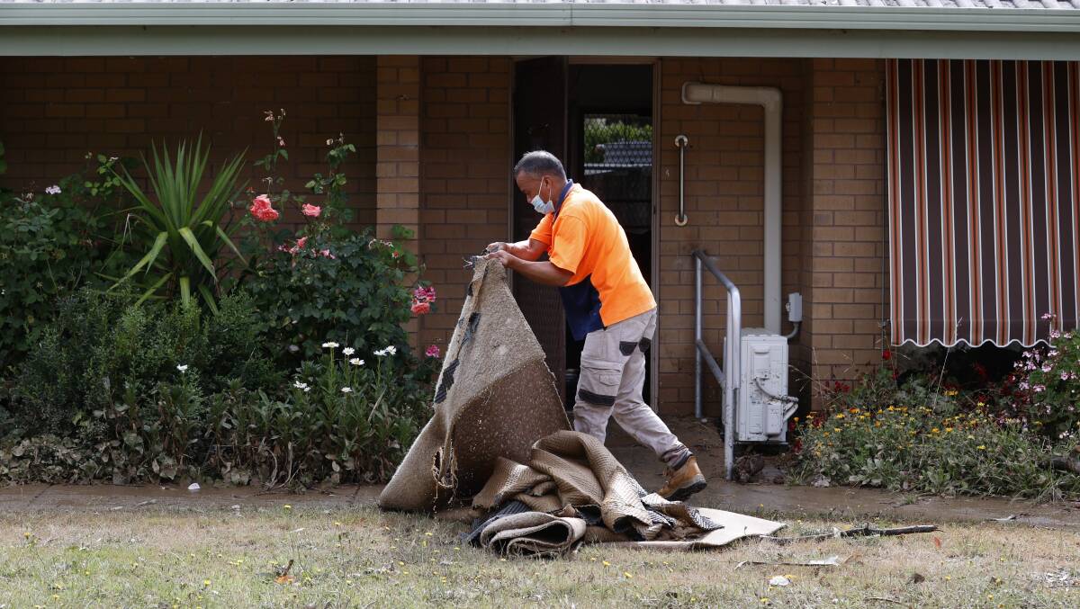 Cleanup crews remove carpet from flooded houses on Thursday morning. Picture: Luke Hemer