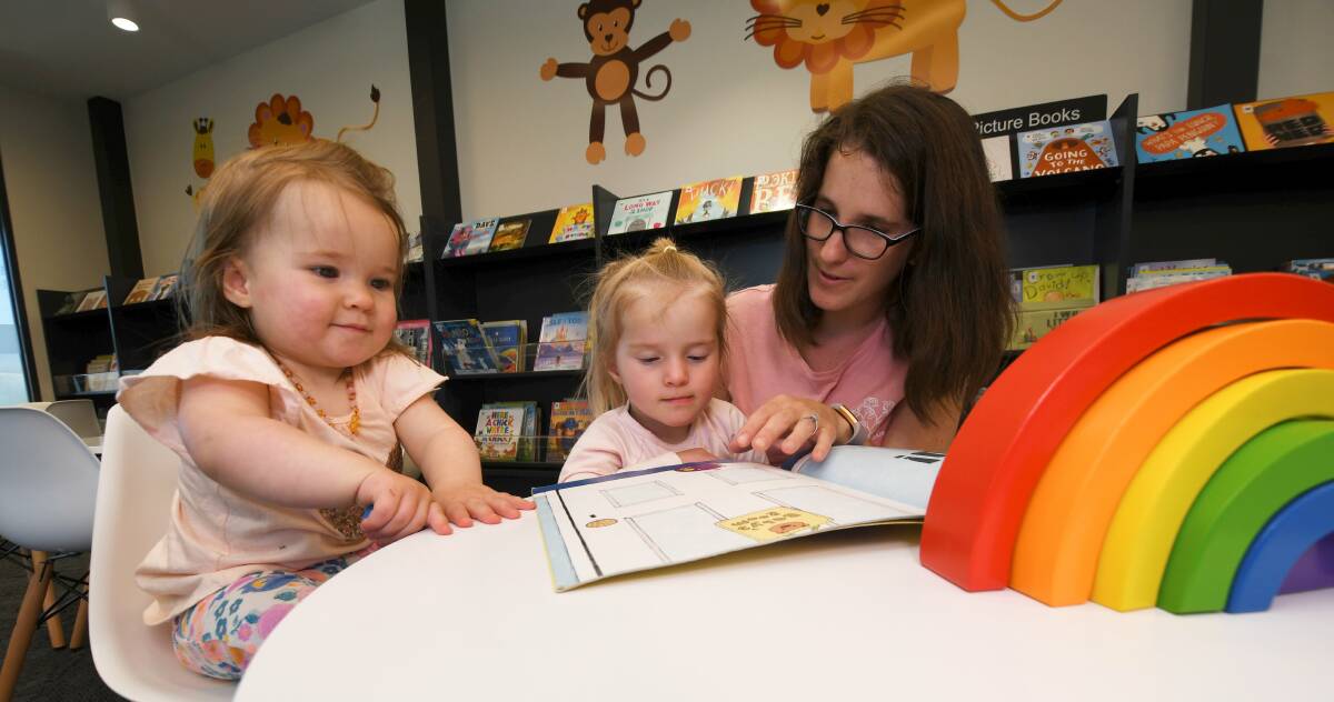 Paris Tomlinson reads to Adeline (aged one) and Daisy Sulja (aged three) at the Sebastopol library. Pictures: Lachlan Bence