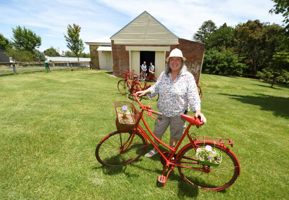 Lorraine Powell, with Roger Permezel and David Powell, will display 35 red bikes around Buninyong for the RoadNats. Pictures: Lachlan Bence