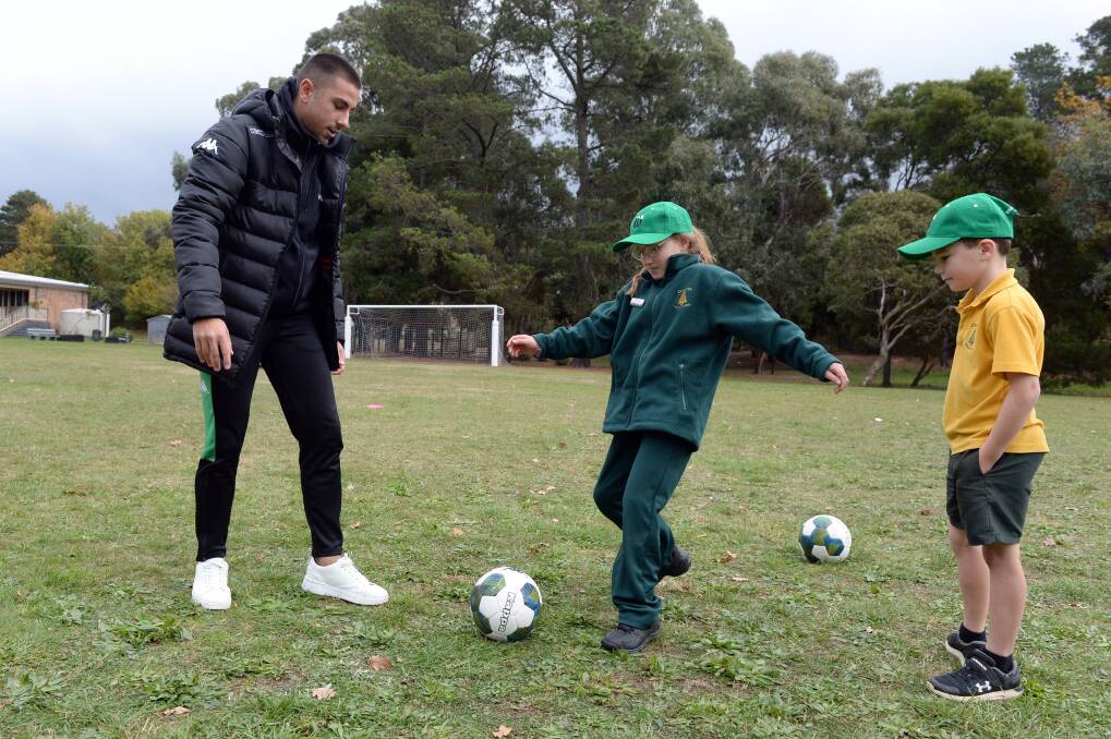 Western United's Dalibor Markovic runs a clinic at Creswick Primary School, showing Allison and Max the ropes. Pictures: Kate Healy
