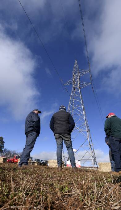 Farmers underneath the Dean 220kv tower. Picture: Lachlan Bence