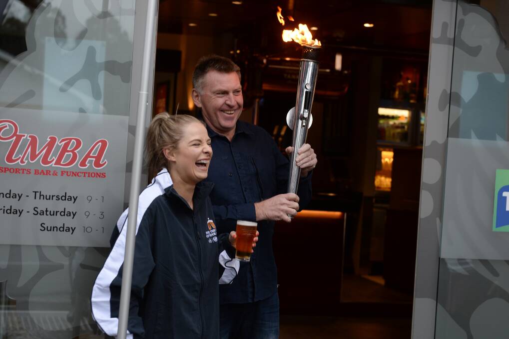 Dave Canny welcomes CUB's Tap Torch runner Tregan Dickson to the Red Lion as part of a "reopening ceremony" promotion.