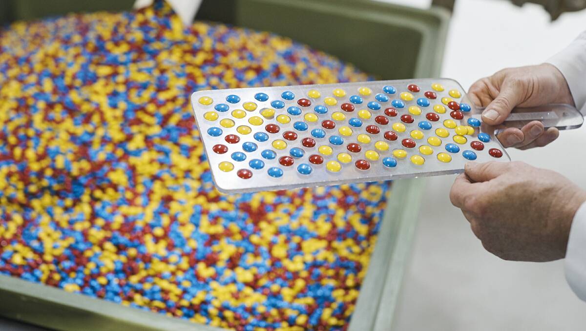 Birthday cake-flavoured M&Ms are inspected by a worker. Picture: contributed