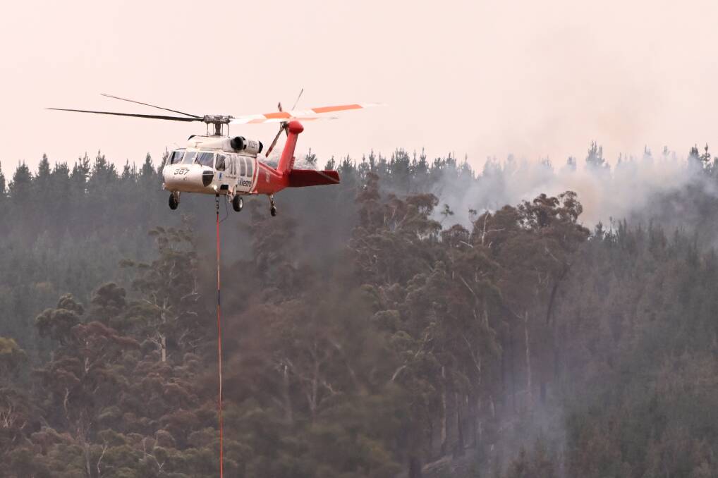 A helicopter based at the Ballarat airport picks up water while fighting a bushfire near Raglan in February. Picture by Adam Trafford