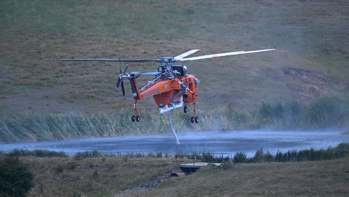 A helicrane refills near the Ross Creek fire on Wednesday. Picture by Kate Healy
