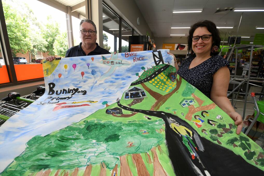 Foodworks manager Alan Nielsen and artist Annie Ross with artwork by Buninyong schoolchildren.