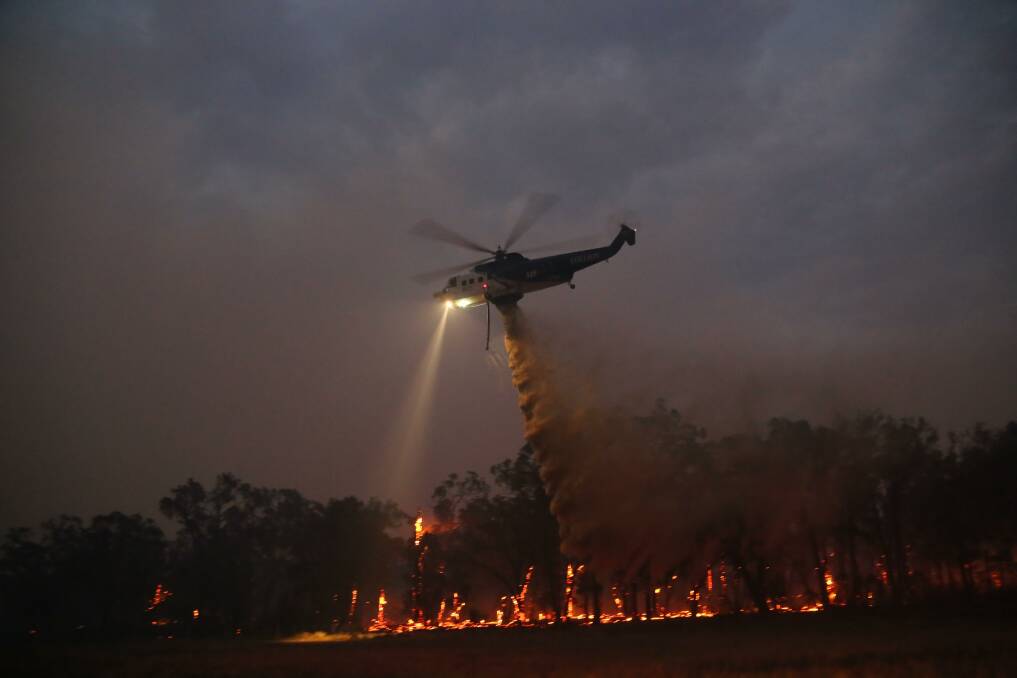A helicopter drops water at night over the Rosedale fire in January 2019. Picture: Andrew Norman, Traralgon Fire Brigade