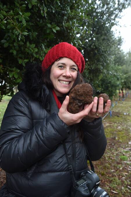 Bounty: Melbourne resident Jodie Harvey looks triumphant with her truffle haul from the Black Cat Truffles feast and forage day, held on Sunday in Wattle Flat, just north of Ballarat. Picture: Kate Healy