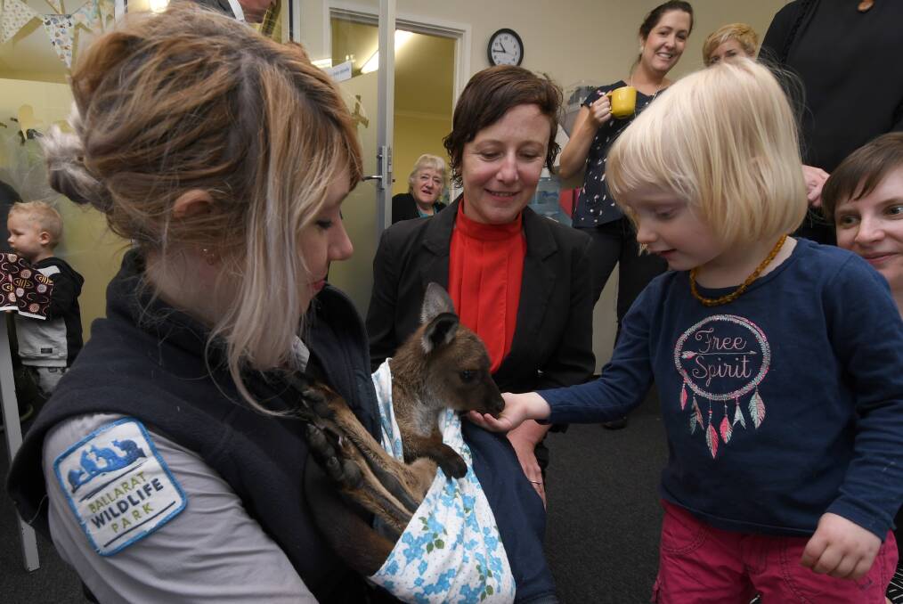 Cuddly: Three-year-old Helena Jones feeds a joey with the help of Ballarat Wildlife Park keeper Hannah Geeson and Cr Belinda Coates. Children under five years can get free entry to the park on October 28. Photo: Lachlan Bence