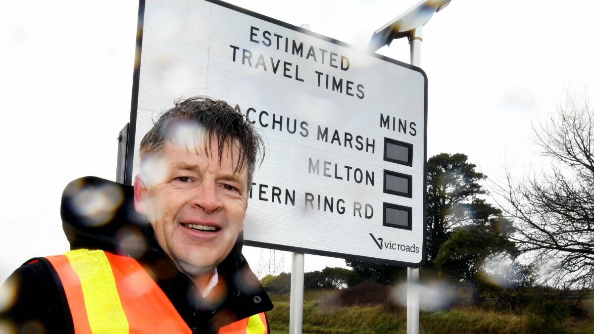 Rain delay: Roads and road safety minister Luke Donnellan stands in front of one of five new signs  in Warrenheip displaying travel times along the Western Highway between Ballarat and Melbourne. Picture: Lachlan Bence 