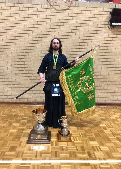 WINNER: Tarl O'Mara holds the National Kendo Championships flag after helping Victoria win in an intense grand final showdown against traditional kendo powerhouse New South Wales. Picture: supplied.