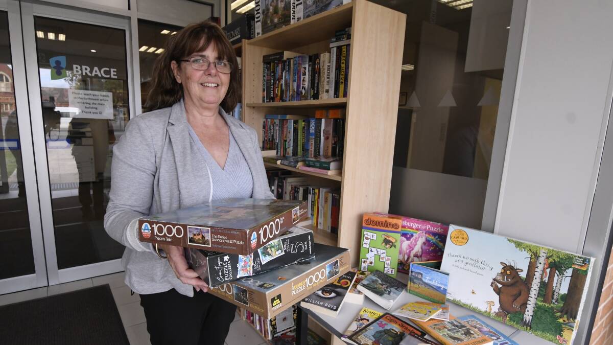 FUN FOR ALL: BRACE regional manager Sandra Gallagher shows off books and puzzles at the community library. Picture: Lachlan Bence.