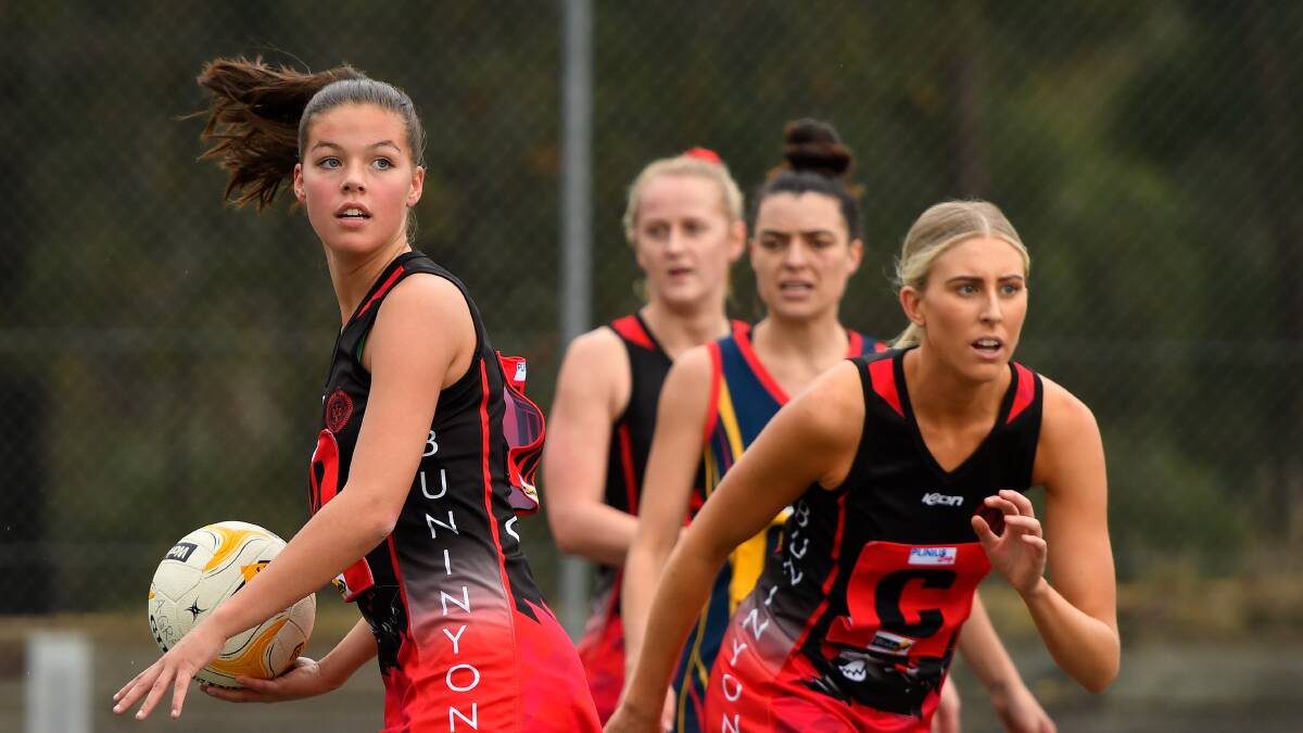 EYES UP: Ella Squire (left) surveys the court in the Buninyong Bombers' 42-goal win against the Beaufort Crows. Picture: Adam Trafford.