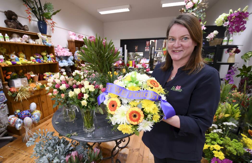 WREATHS: Boronia Exclusive Florists owner Julie Collins shows off one of the Anzac wreaths her business has prepared for Anzac Day. Picture: Lachlan Bence.