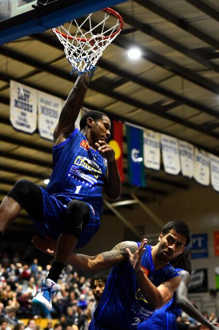 SLAM: Marqueze Coleman hangs from the rim following a big dunk against the Bandits. Picture: Adam Trafford.