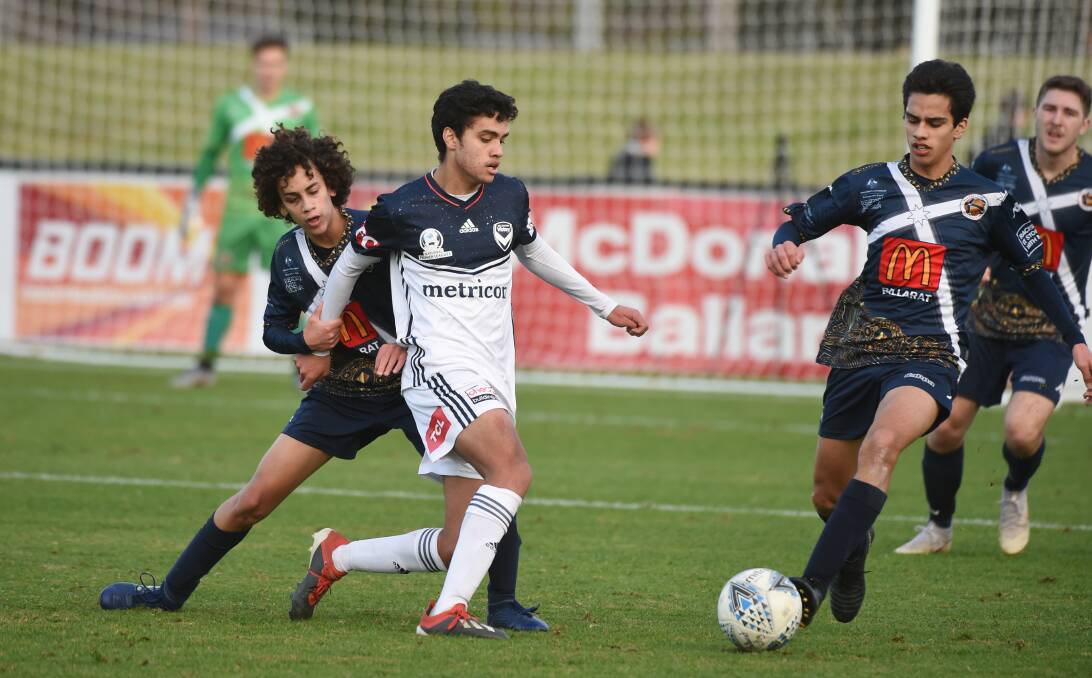 FAMILY: Brandon Lauton (white) dribbles the ball against his brothers Jordan (left) and Leighton (right) when facing off against Ballarat City. Picture: Kate Healy.