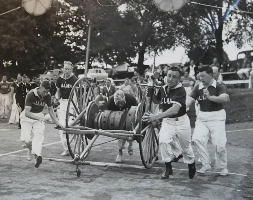 HARD PUSH: Stan Kneeshaw (front right) and his fellow Ballarat Firefighters push a rose reel.