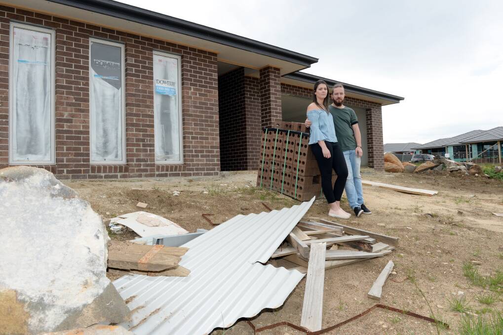Aaron Stoddart and Kristy Kinnersly in front of their unfinished Lucas home. Picture: Kate Healy 