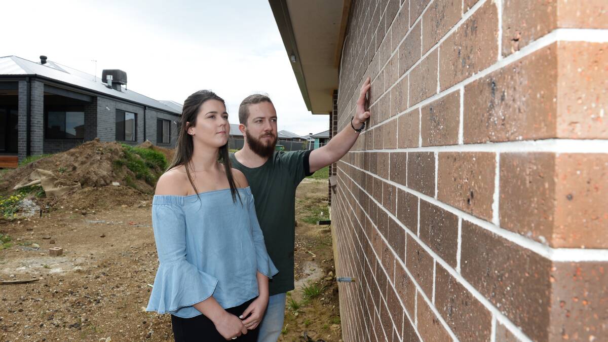 Aaron Stoddart and Kristy Kinnersly inspecting the brickwork at their Lucas home. Picture: Kate Healy 