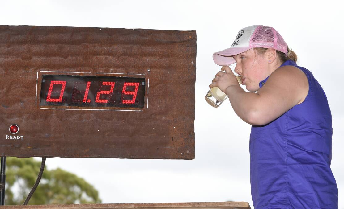 Speedy: Lauren Bailey from Napoleons races the clock as she tries to finish one litre of mineral water at the Glenlyon Mixed Sports Day. Picture: Kate Healy. 