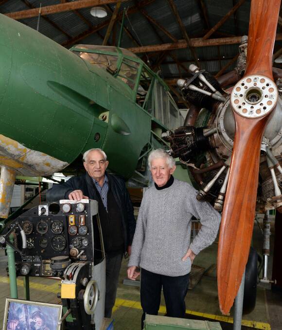 A World War 2 workhorse: Alan Penhall and David Lacy beneath the cockpit of the Avro Anson Mk1 at Ballarat Airport. They hope to get more public support to continue its restoration. Photo: Kate Healy.