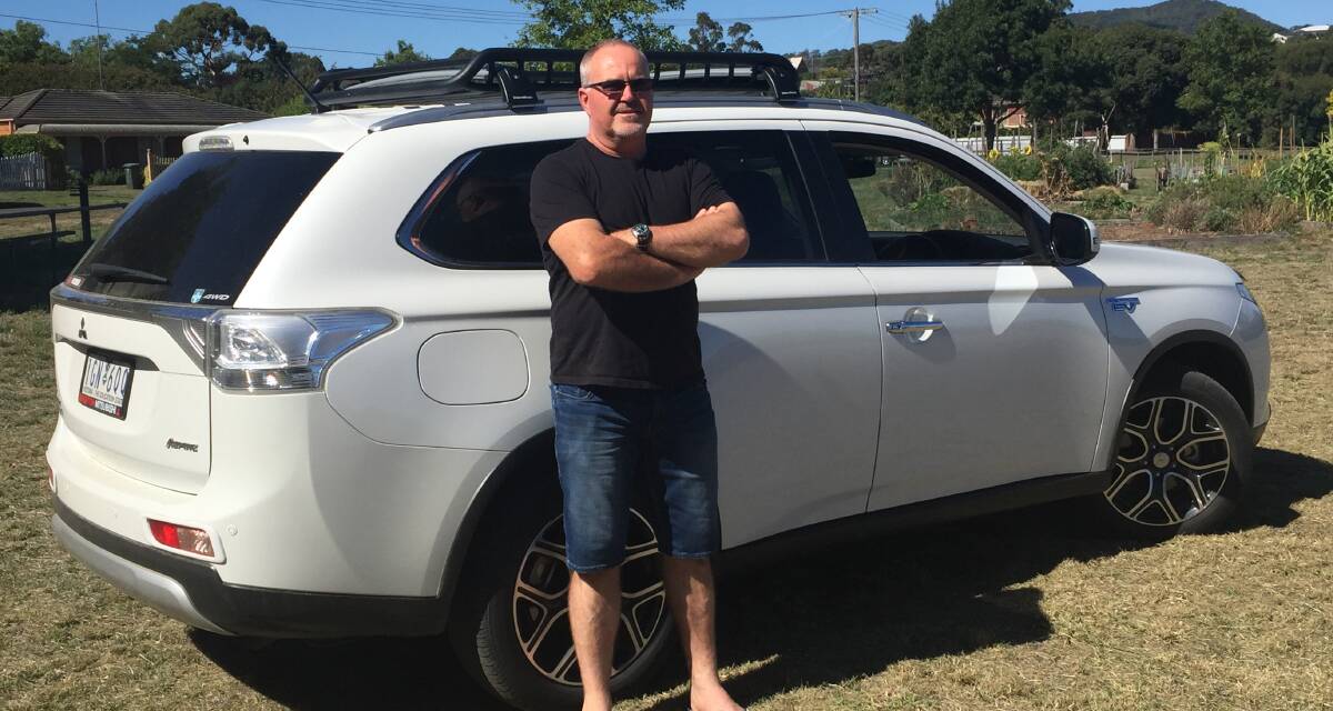 Fuel, hybrid or pure electric: Bruce Cameron with his Mitsubishi Outlander. Mr Cameron says electric cars will become cheaper very rapidly. Picture: Caleb Cluff.