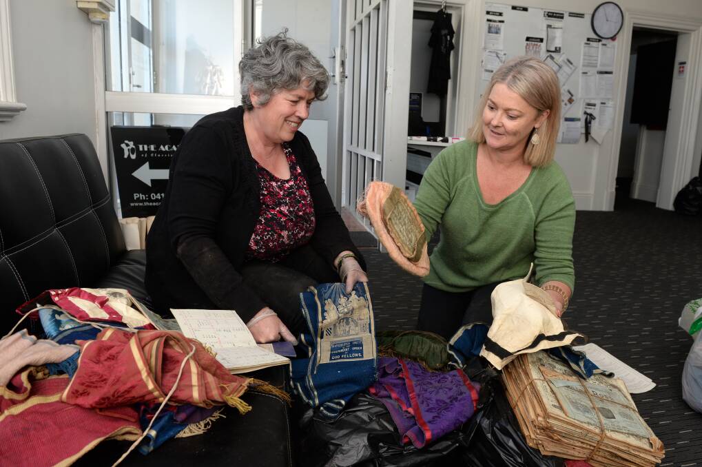 Rare discovery: Clare Gervasoni and Kellie Fishwick-Roscoe with some of the artefacts discovered in the roof of the Unity building on Grenville St. Picture: Kate Healy.