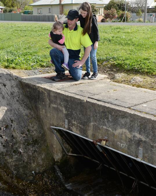 The drain at Buninyong: Sophie Spano, 18mths, Joe Spano and Zoe Spano, 7. Picture: Kate Healy.