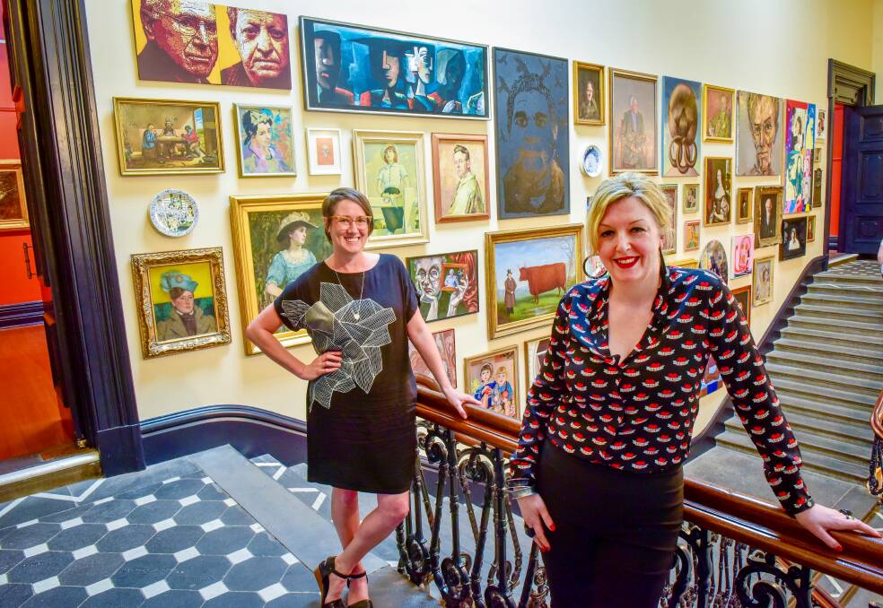 Story focus: AGB curator Julie McLaren (left) and gallery director Louise Tegart in front of the new staircase salon hang at the gallery. The portraits range from the C19 to contemporary Archibald winners. Picture: Brendan McCarthy.